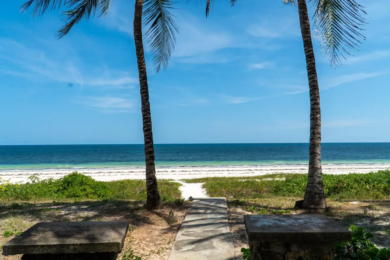 Garden path through palms leading onto the white sand of Bofa Beach