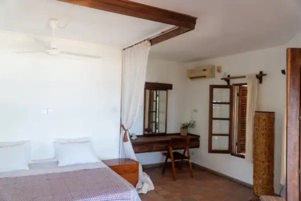 Bright bedroom with double bed, ceiling fan and writing desk