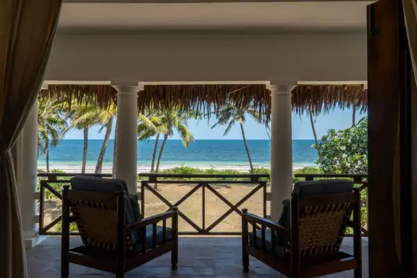 Veranda armchairs looking out through palms to the ocean