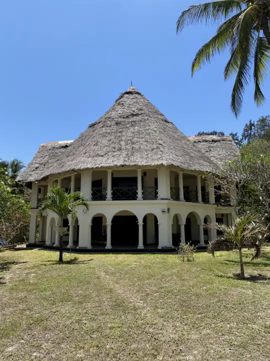 The villa from the lawn under a clear blue sky