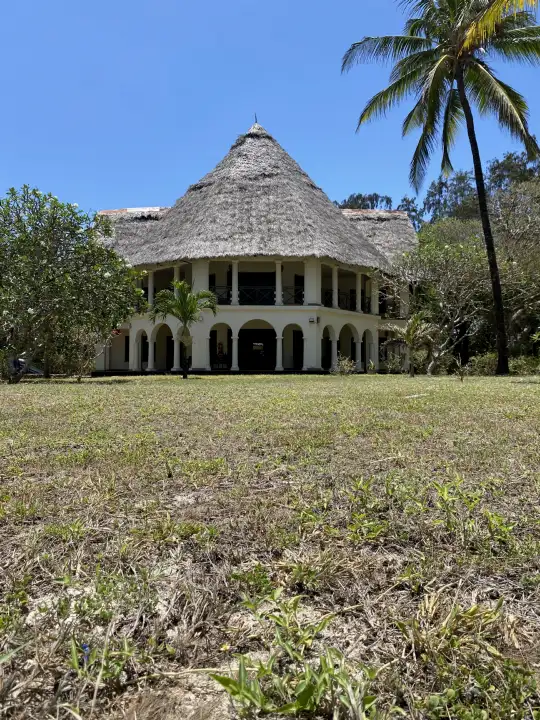 Low view across the lawn to the makuti-roofed villa